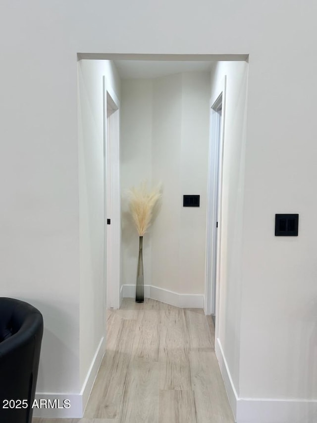 hallway with light hardwood / wood-style floors