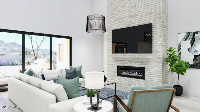living area with a towering ceiling, a brick fireplace, and wood finished floors