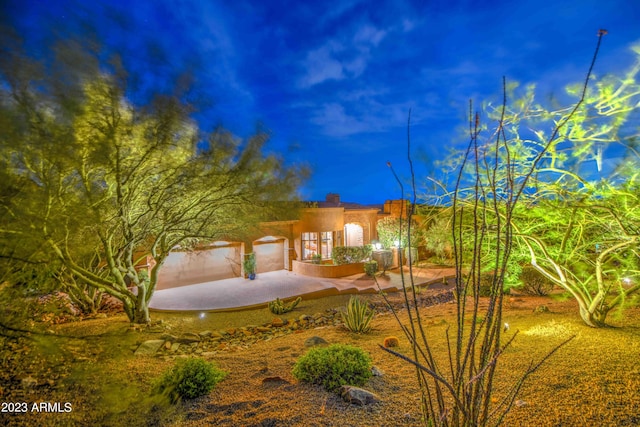 yard at night featuring a garage