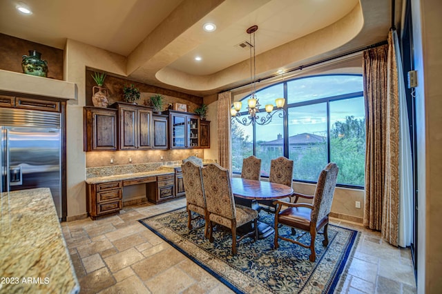 tiled dining room featuring a notable chandelier and a tray ceiling