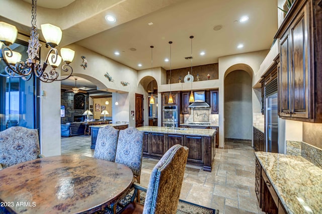 dining room featuring light tile floors, sink, and ceiling fan with notable chandelier