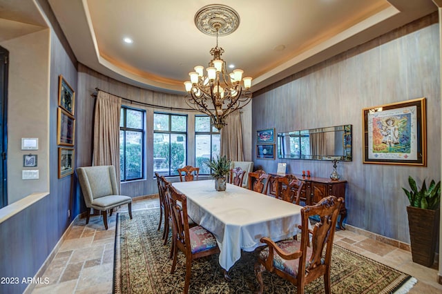 dining room with an inviting chandelier, light tile floors, and a tray ceiling