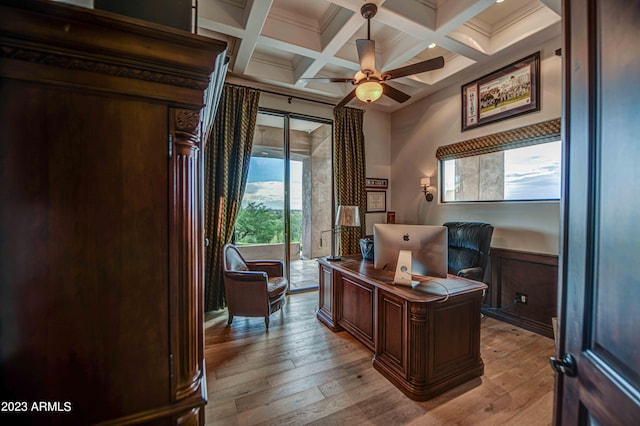 office with coffered ceiling, light hardwood / wood-style floors, ceiling fan, beamed ceiling, and ornamental molding