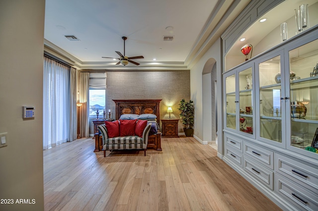 bedroom with light hardwood / wood-style floors and a raised ceiling