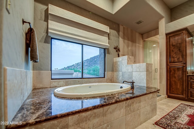 bathroom with a mountain view, shower with separate bathtub, and tile flooring