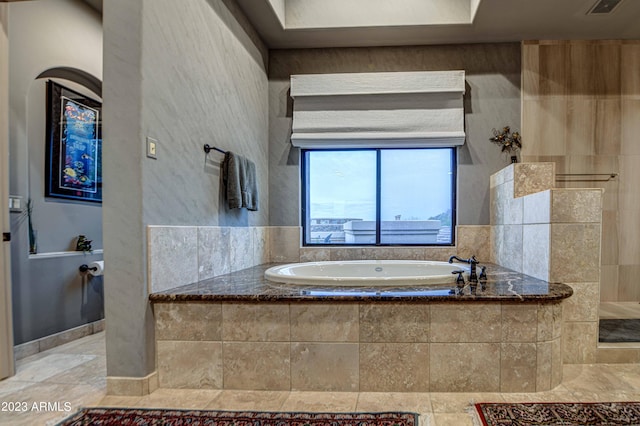 bathroom with tiled bath and tile flooring