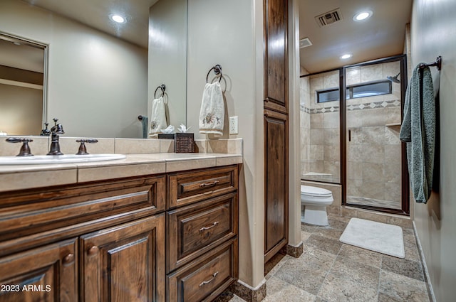 bathroom featuring vanity, tile floors, a shower with shower door, and toilet