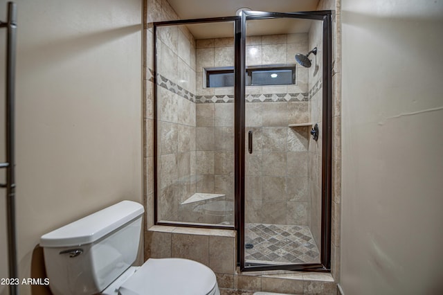 bathroom with tile walls, toilet, and an enclosed shower