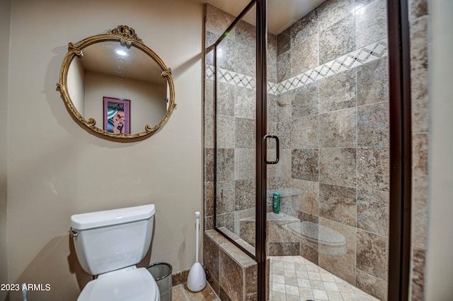bathroom with a shower with door and toilet