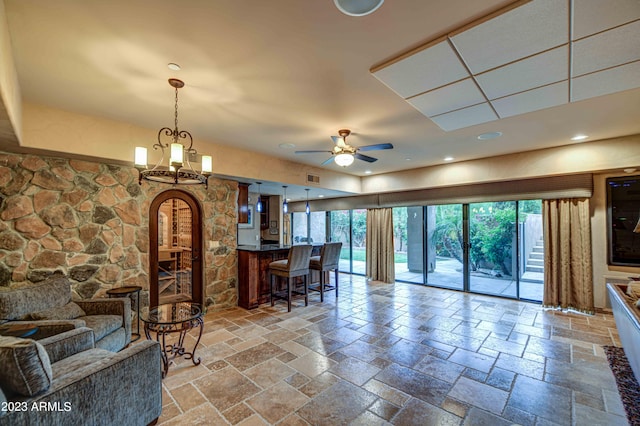 interior space featuring ceiling fan with notable chandelier