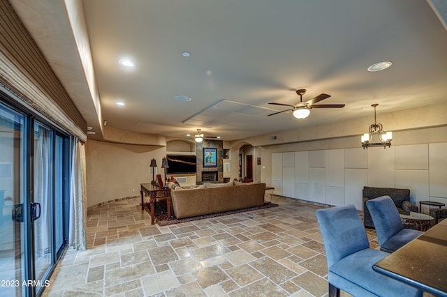 tiled living room featuring ceiling fan with notable chandelier