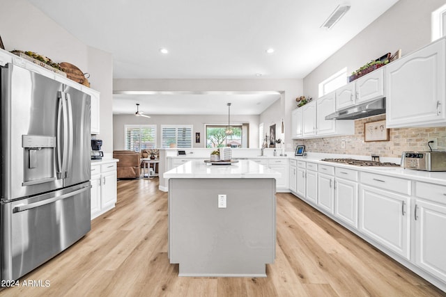 kitchen with pendant lighting, appliances with stainless steel finishes, kitchen peninsula, and white cabinets