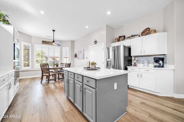 kitchen with white cabinetry, appliances with stainless steel finishes, gray cabinetry, and a kitchen island