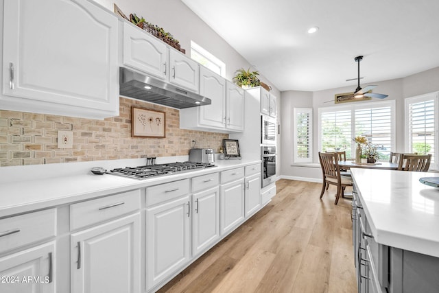 kitchen featuring decorative backsplash, white cabinetry, light hardwood / wood-style flooring, and ceiling fan