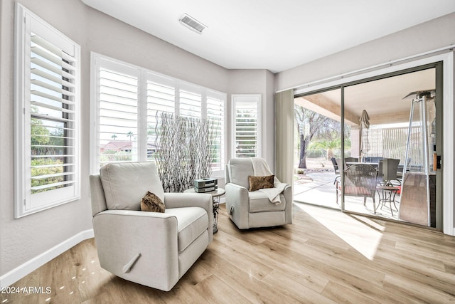 living area featuring light hardwood / wood-style floors and a healthy amount of sunlight