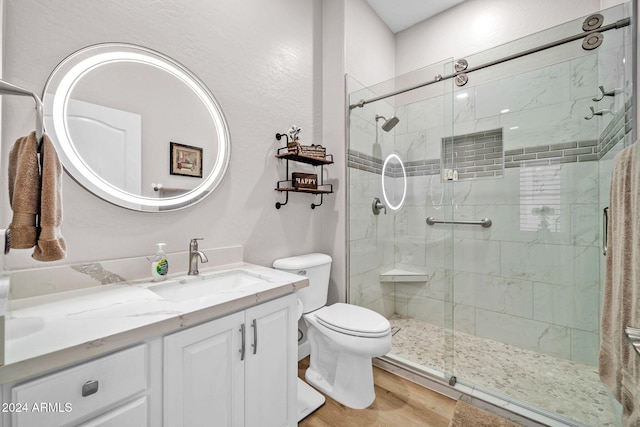 bathroom featuring toilet, a shower with shower door, hardwood / wood-style floors, and vanity