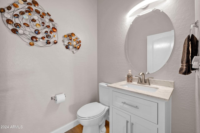 bathroom with vanity, hardwood / wood-style floors, and toilet