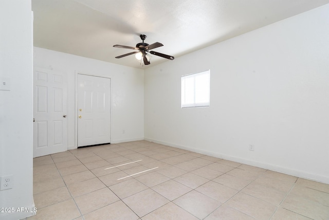 tiled empty room featuring ceiling fan