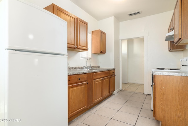 kitchen with sink, white appliances, and light tile patterned floors