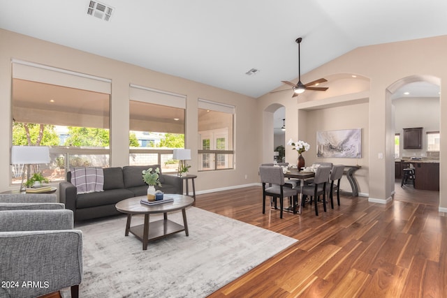 living room with ceiling fan, vaulted ceiling, and dark wood-type flooring