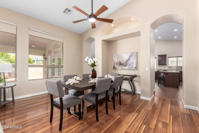 dining area with high vaulted ceiling, dark wood-type flooring, and ceiling fan