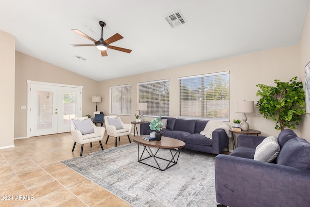 tiled living room with ceiling fan, vaulted ceiling, a healthy amount of sunlight, and french doors