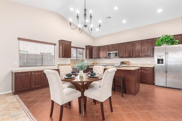 dining area with high vaulted ceiling, a chandelier, and light tile patterned floors