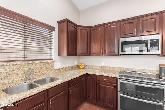 kitchen featuring range, sink, and light stone countertops