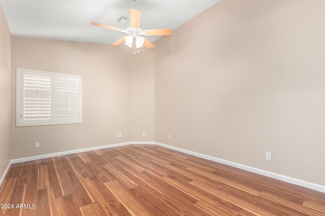 empty room with lofted ceiling, wood-type flooring, and ceiling fan