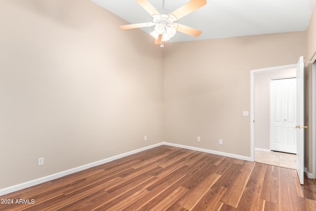 spare room featuring ceiling fan, vaulted ceiling, and wood-type flooring