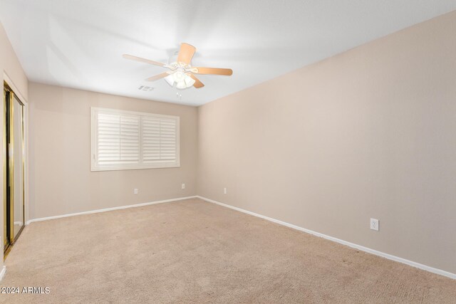 carpeted spare room featuring ceiling fan