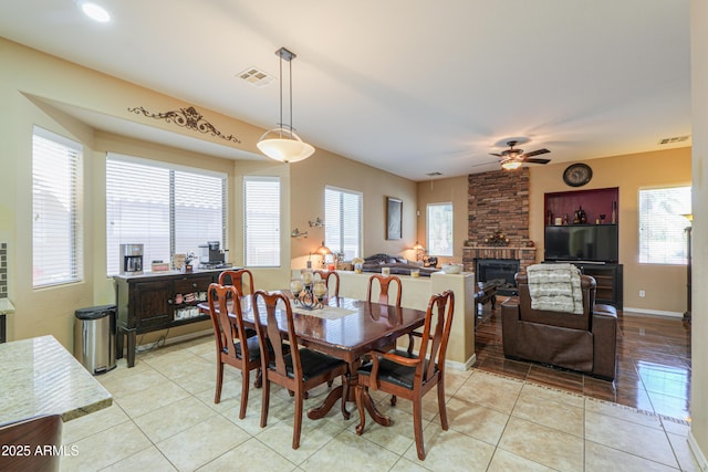 2115 N Cougar Ct, Casa Grande, AZ 85122 - dining space featuring light tile patterned floors, a stone fireplace, a ceiling fan, and visible vents