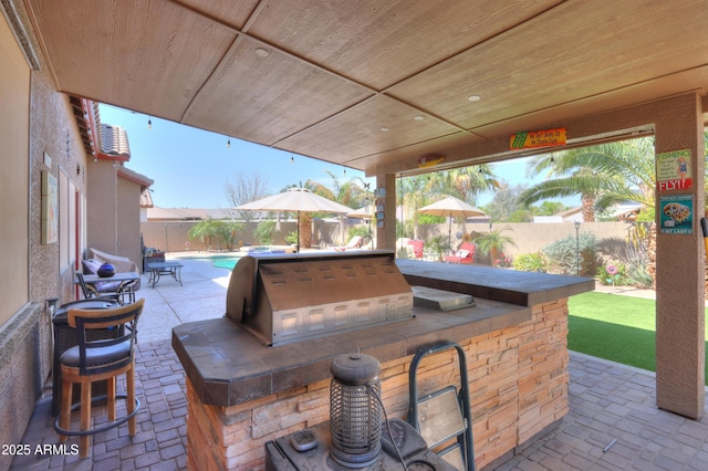 2115 N Cougar Ct, Casa Grande, AZ 85122 - view of patio featuring a fenced backyard, exterior kitchen, a fenced in pool, and outdoor dry bar