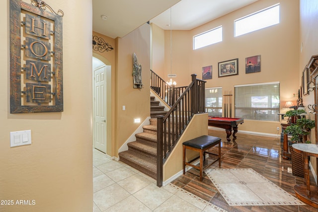2115 N Cougar Ct, Casa Grande, AZ 85122 - staircase with baseboards, arched walkways, a high ceiling, billiards, and tile patterned flooring