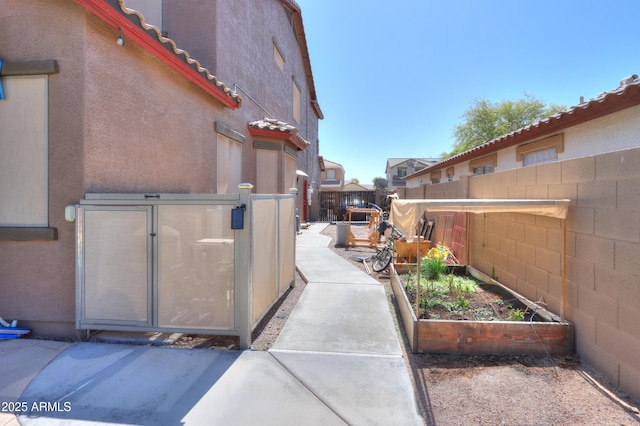 2115 N Cougar Ct, Casa Grande, AZ 85122 - view of side of property featuring a tiled roof, a garden, fence, and stucco siding