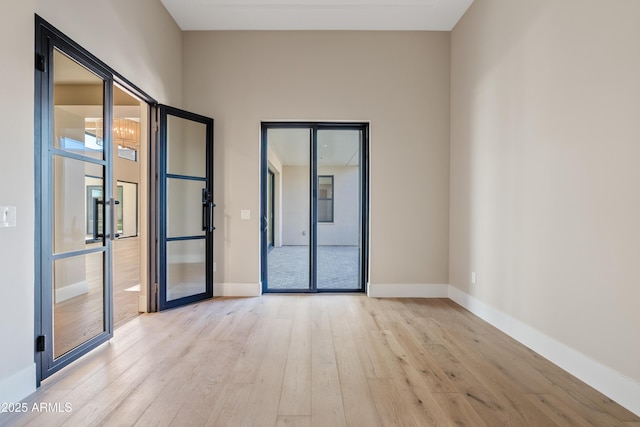 empty room with light wood-type flooring and french doors