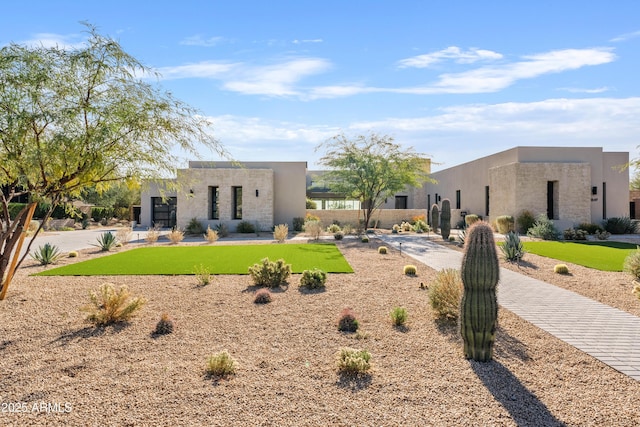 pueblo-style home featuring a front yard