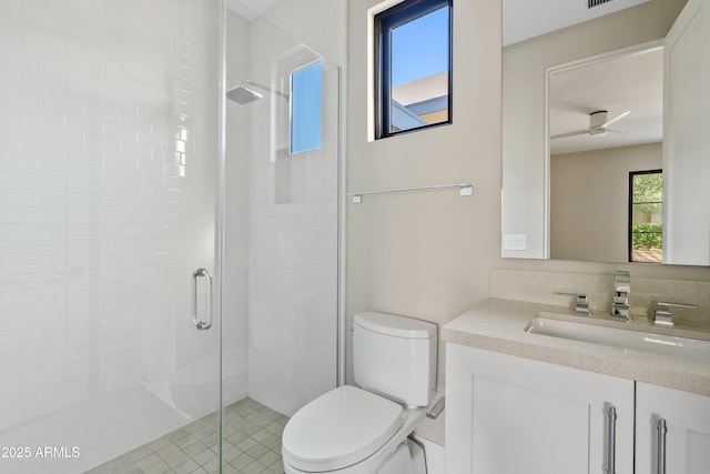 bathroom featuring vanity, ceiling fan, toilet, and a shower with door