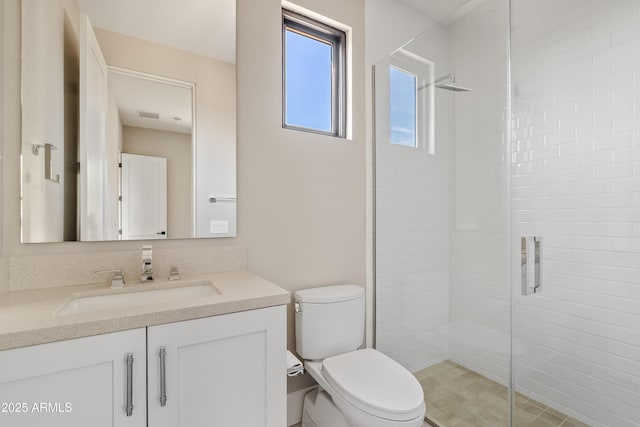 bathroom featuring vanity, an enclosed shower, and toilet