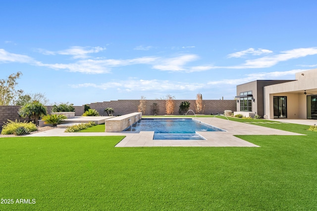 view of swimming pool with pool water feature, a patio, and a lawn