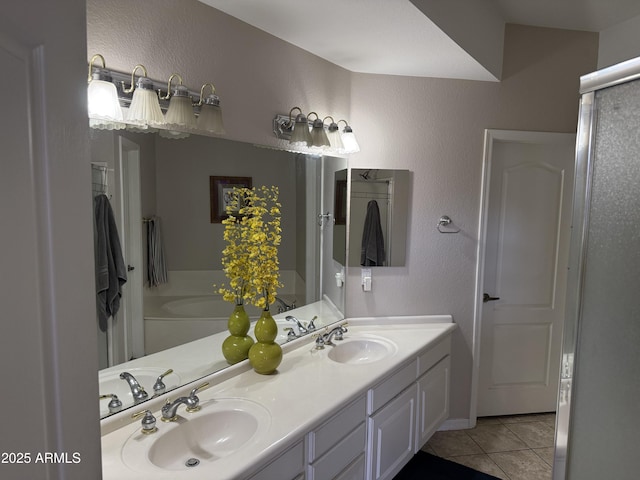 bathroom with tile patterned flooring, a bathtub, and vanity