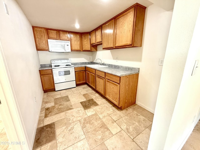 kitchen with brown cabinets, white appliances, stone tile floors, and light countertops