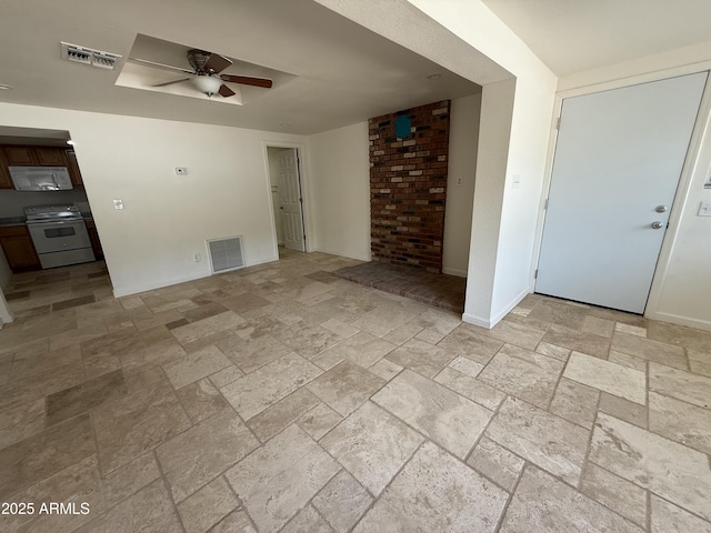 interior space with a ceiling fan, stone finish floor, visible vents, and baseboards