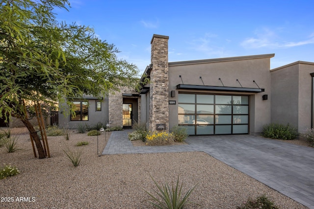 12311 E Black Rock Rd, Scottsdale, AZ 85255 - modern home featuring decorative driveway, stucco siding, a garage, and a chimney
