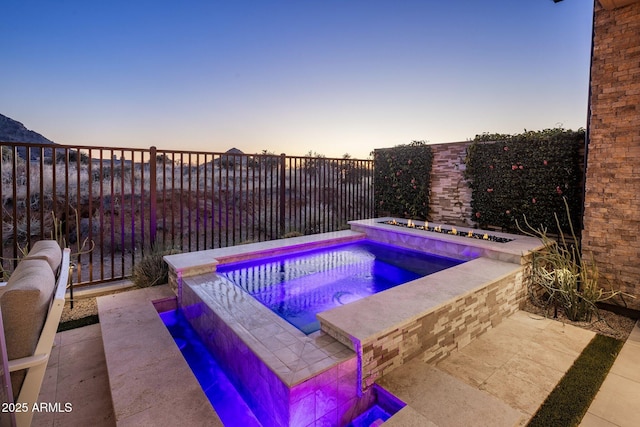 12311 E Black Rock Rd, Scottsdale, AZ 85255 - pool at dusk featuring an in-ground hot tub and a fenced backyard