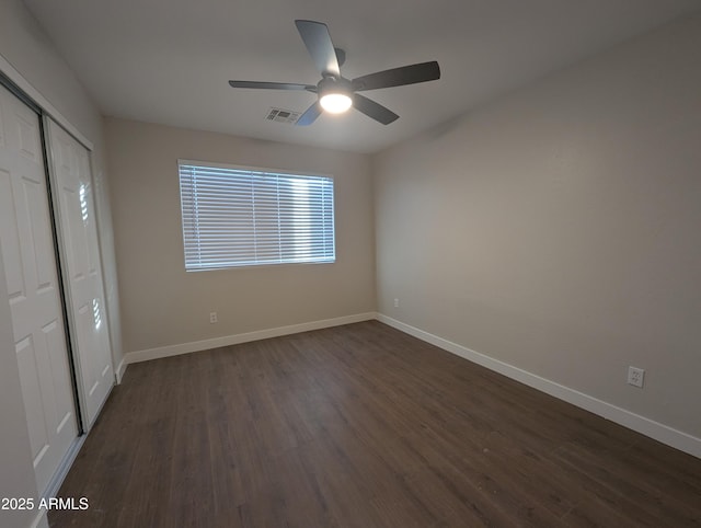 unfurnished bedroom featuring ceiling fan, dark hardwood / wood-style floors, and a closet