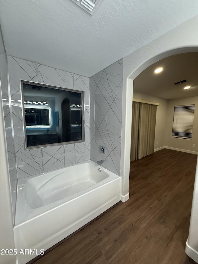 bathroom with wood-type flooring and a textured ceiling