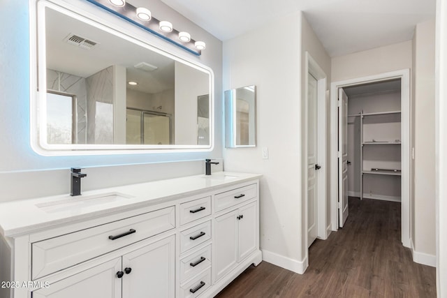 bathroom featuring hardwood / wood-style flooring, vanity, and a shower with shower door