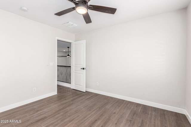 unfurnished room with dark hardwood / wood-style floors and ceiling fan