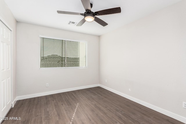 unfurnished room featuring dark wood-type flooring and ceiling fan